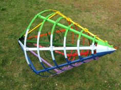 a colorful kite is laying on the grass