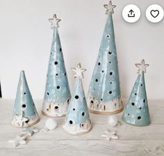 four blue ceramic christmas trees with stars on them