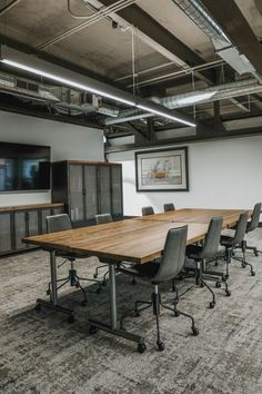 an empty conference room with chairs and a large wooden table in the middle of it