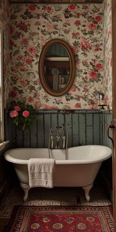 an old fashioned bathtub with flowers on the wall and rug in front of it