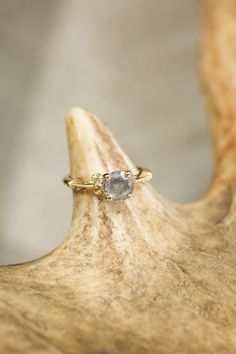 a gold ring with a gray diamond on it