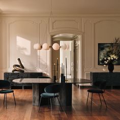 an elegant dining room with wooden floors and white walls