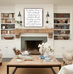 a living room filled with furniture and a fire place in front of a book shelf