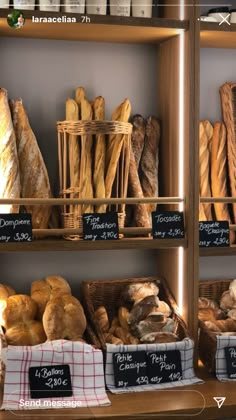 breads and pastries are displayed on shelves in a bakery