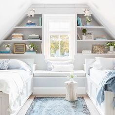 two beds in a room with white walls and carpeted flooring, built - in bookshelves