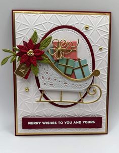 a christmas card with a sleigh and poinsettis on the side