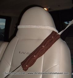 a crocheted headband is attached to the back of a car's seat