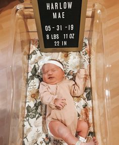 a baby is laying in a plastic chair with a sign on it's back