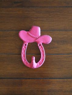 a pink horse shoe shaped like a cowboy's hat on top of a wooden table