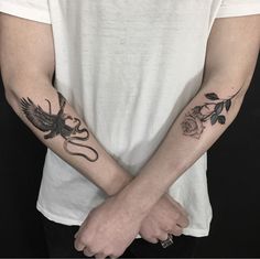 two people with tattoos on their arms holding hands