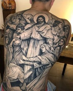 the back of a man's body with tattoos on it and an image of jesus holding