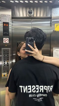 a man and woman taking a selfie in an elevator