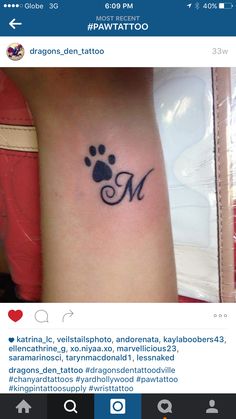 a dog paw with the letter m on it's left arm and an initial tattoo