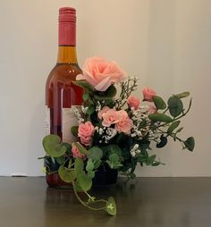 a bottle of wine and some flowers on a table