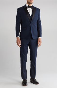 Bring understated elegance to the table in this three-piece tuxedo crafted from rich fabric in a classic single-breasted silhouette. Jacket has shawl collar; chest welt pocket; front welt pockets Vest has front button closure; V-neck Pants have zip fly with button closure; front slant pockets; back button-welt pockets Jacket and vest are lined; trousers are lined to the knee 65% polyester, 35% viscose Dry clean Imported Each suit has a 6” drop, meaning that a size 38R jacket is paired with size Fitted Semi-formal Set With Suit Collar, Semi-formal Slim Fit Suiting Fabric Set, Elegant Fitted Sets With Suit Collar, Formal Tuxedo Sets With Slim Fit, Elegant Black Tie Slim Fit Three-piece Suit, Fitted Tuxedo Sets For Formal Occasions, Party Slim Fit Suit In Suiting Fabric, Classic Formal Sets With Custom Fit, Classic Custom Fit Suiting Fabric Sets