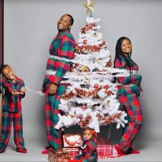 a man and woman standing next to a christmas tree