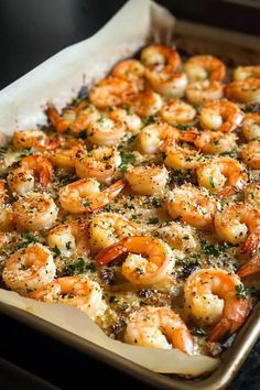 a pan filled with cooked shrimp and garnished with parmesan sprinkles