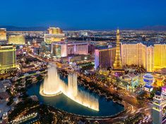 the las vegas strip is lit up at night with fountains in the foreground and other buildings around it