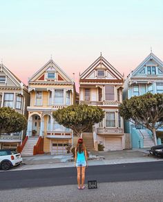 a woman is standing in front of some houses