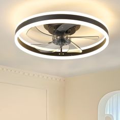 a ceiling fan that is mounted to the ceiling in a room with white walls and windows