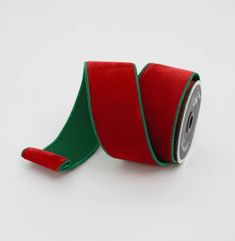 a roll of red and green ribbon on a white background