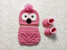 a pink crocheted hat and booties with a heart on it