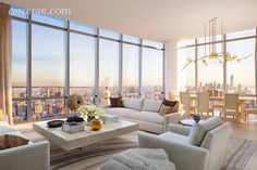 a living room filled with furniture and large windows overlooking the cityscape in the distance