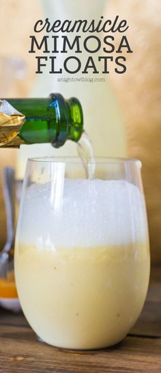 a glass filled with white liquid being poured into it and topped with an ice creamsice