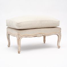 a white bench with two pillows on it's legs and one pillow sitting on top