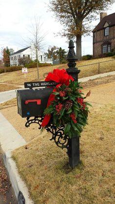 a mailbox decorated with red flowers and greenery