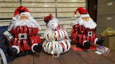 three santa clause decorations sitting on top of a wooden table next to a cardboard box