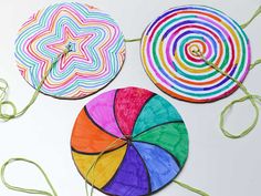 three paper plates with different colored designs on them and one has a string attached to it