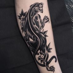 a black and white tattoo on the arm of a person with a lizard design on it