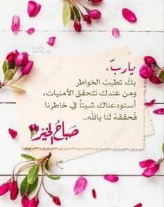 a piece of paper with arabic writing on it and pink flowers around the page in front