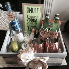 an assortment of liquors and drinks in a metal tray with a bow on the side