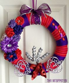 a purple and red wreath hanging on a door