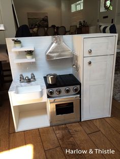 a model kitchen with an oven, sink and stove top in it's display area