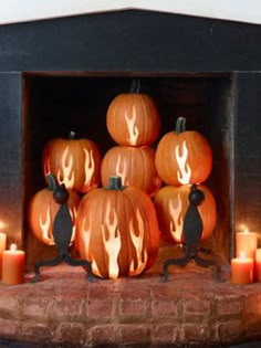 pumpkins with flames carved into them sitting in front of candles