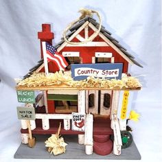 a small red and white house with a sign on it's roof that says country store