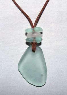 a piece of glass sitting on top of a brown cord with a white bead around it