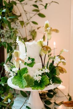 a white wedding cake with flowers and greenery