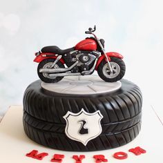 a red motorcycle is on top of a black tire with the number 2 below it