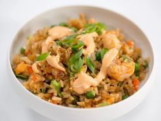 a white bowl filled with rice and veggies covered in peanut sauce on top