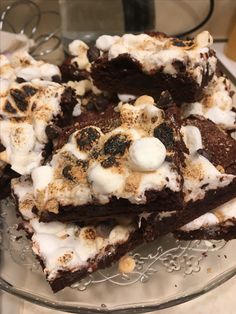 there are brownies with marshmallows on top of each other in a glass plate