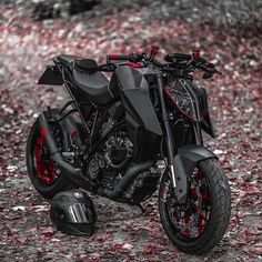 a black and red motorcycle parked in the woods