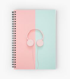 a spiral notebook with headphones on the cover and pastel pink and mint green background