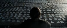 a person standing in front of a wall with squares on it and looking at the ground