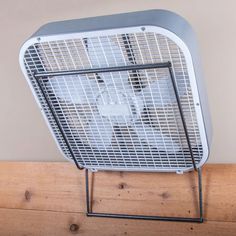 a metal fan sitting on top of a wooden table