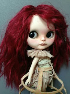 a doll with long red hair wearing a dress