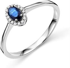 a white gold ring with an oval shaped blue sapphire and diamonds on the top, set in